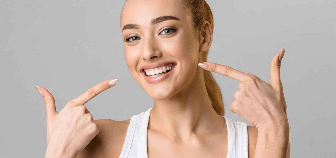 Young Girl Showing her Teeth with Pointing Fingers | Smile Virtual